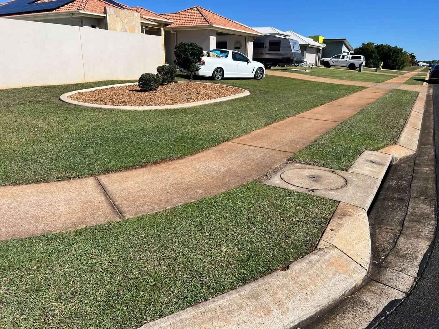 Curved concrete paths running through a mown front lawn